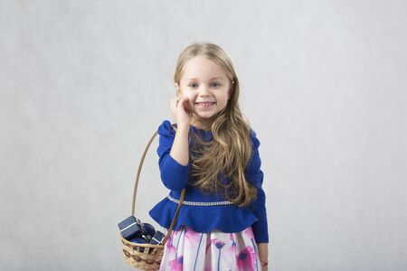 Beautiful girl in a blue jacket with a straw country korzinka blonde in a pink dress
