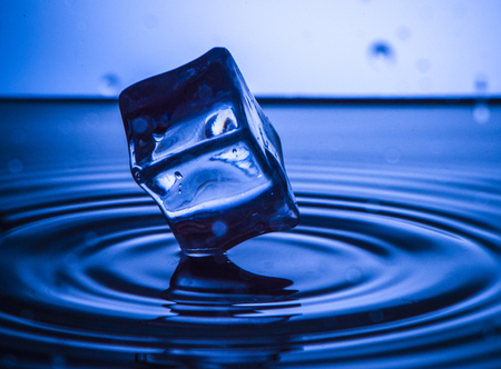 Water splash of blue cube and blue liquide with wavesの写真素材
