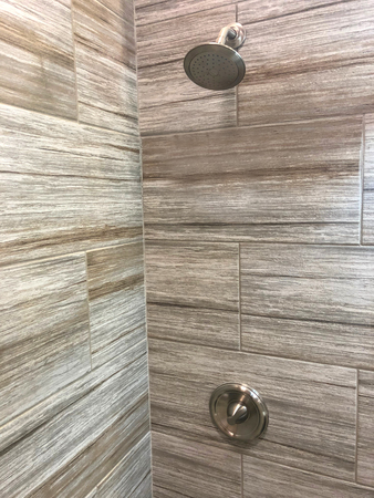 bathroom shower with beautiful decorative stone tiles shower head and shower handle in chromeの写真素材