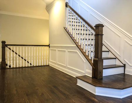 Stairs of the luxury house with white walls, wood panels in white color, dark cherry hardwood floorの写真素材