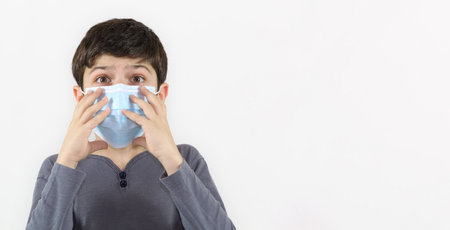 teenager boy in a medical mask on a white background. Protection against coronavirus and fluの写真素材