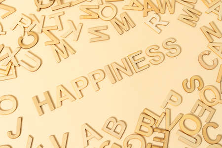 HAPPY sign with wooden letters scattered all over on the beige backgroundの写真素材