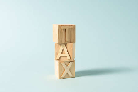 TAX word on wooden cubes on the light blue background, letters, alphabetの写真素材