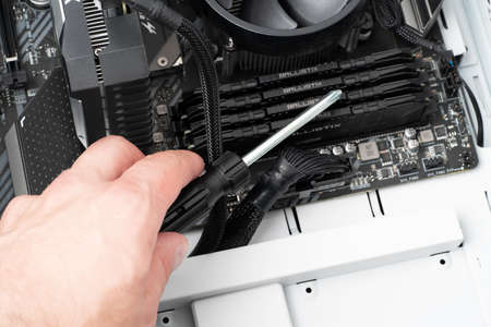 Hands of computer engineer repairing a modern desktop