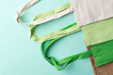Reusable, eco friendly cotton and jute bags on the green background