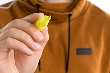 A close up image of man's hand holding a yellow marker