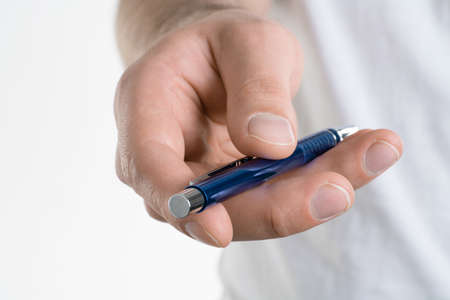 A close up image of Man's hand holds a pen isolated on white backgroundの写真素材