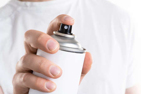 Man's hand holds a can of aerozols isolated on white background