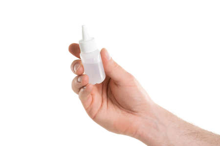 Man's hand holding a white bottle of glue isolated on white backgroundの写真素材