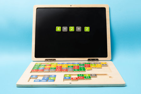 Educational wooden kid laptop with magnetic letters and numbers for learning. Mathematic equation made of numbers.の写真素材