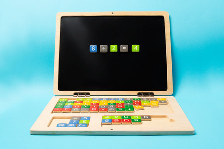 Educational wooden kid laptop with magnetic letters and numbers for learning. Mathematic equation...