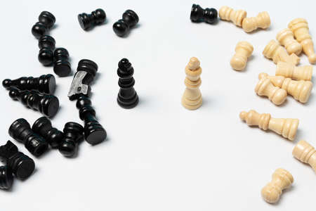 Top view of wooden chess board and chess pieces scattered on the white background.の写真素材