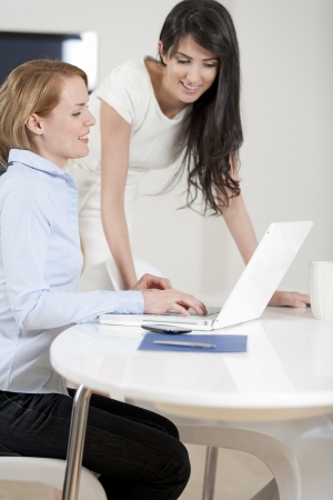 Two colleagues working in an office discussing businessの写真素材