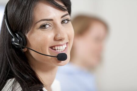 Two colleagues working in a busy call centre office.の写真素材