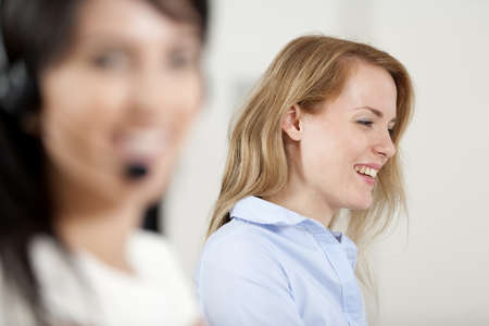 Two colleagues working in a busy call centre office.の写真素材