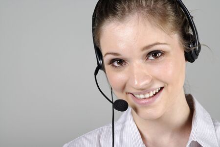 Young woman wearing a telephone headset talking on the phoneの写真素材
