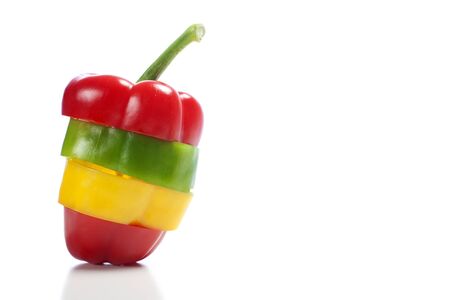 Red Yellow and Green peppers sliced and mixed up to look like one pepper on isolated white backgroundの写真素材