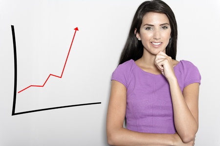 Professional working woman in corporate purple dress, with a concept graph displaying an increase.の写真素材