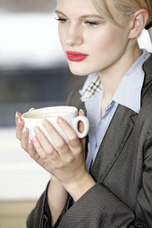 professional business woman drinking a mug of coffee at work.の写真素材