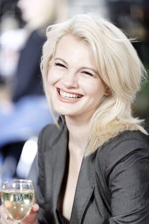 Attractive young woman enjoying a glass of white wine in a wine bar.の写真素材