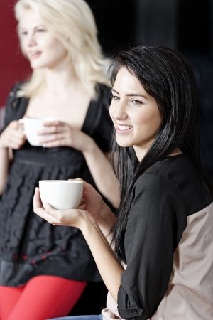 Beautiful young woman talking over coffee at a wine bar.の写真素材