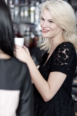 Beautiful young woman talking over coffee at a wine bar.の写真素材