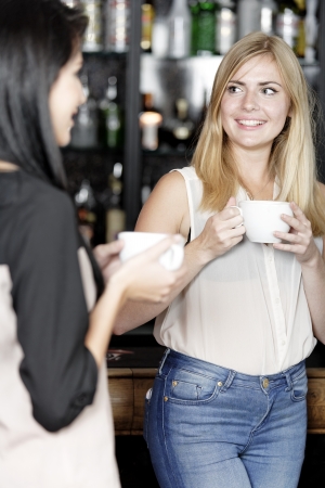 Beautiful young woman talking over coffee at a wine bar.の写真素材