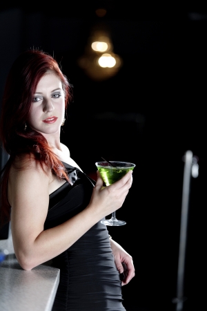 Beautiful young woman enjoying a cocktail drink at a barの写真素材