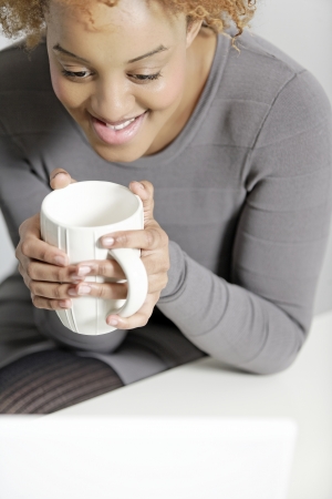 Beautiful young business woman taking a break at her deskの写真素材