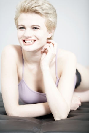 Beautiful young woman relaxing on her sofa at home in pyjamas.の写真素材