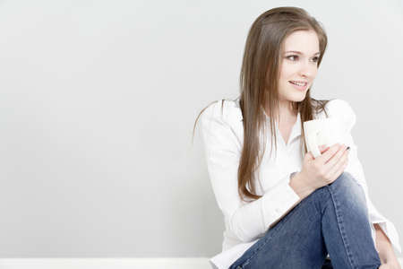 Beautiful young woman relaxing at home with a coffeeの写真素材