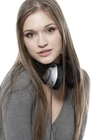 Attractive young woman listening to music on her headphones on a white background.の写真素材