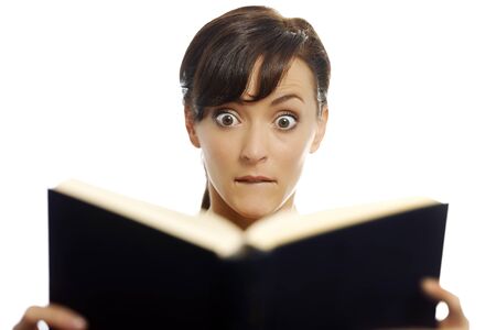 Young woman reading a scary bookの写真素材