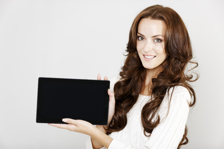 Woman holding up her tablet display teaching or showingの写真素材