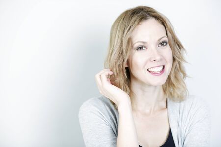 Beautiful young woman wearing a casual cardigan smilingの写真素材