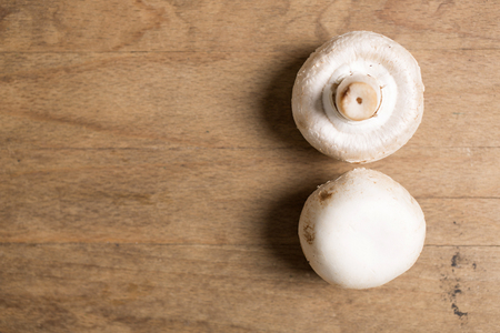Selection of fresh raw mushrooms on a wooden kitchen work surfaceの写真素材