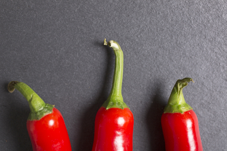 Fresh red chilli on black slate with copy spaceの写真素材