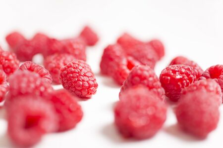 Fresh red raspberries on a light wooden kitchen surfaceの写真素材
