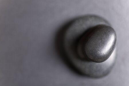 Looking down onto a pile of spa hot rocks on a slate tableの写真素材