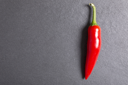 Fresh red chilli on black slate with copy spaceの写真素材