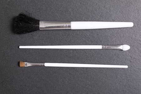 Stylish make up brushes on a black slate surface of all sizesの写真素材