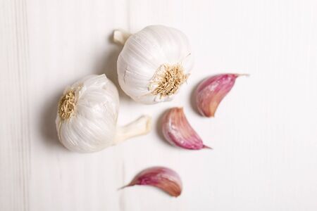 Fresh raw garlic on a light wooden kitchen work surfaceの写真素材