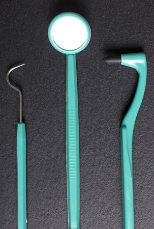 Selection of dentist brushes and tools on a black slate surfaceの写真素材