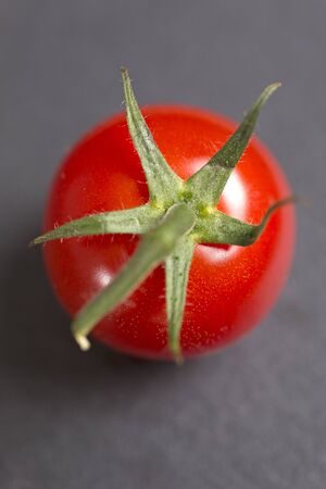 fresh ripe tomatoes on black slateの写真素材