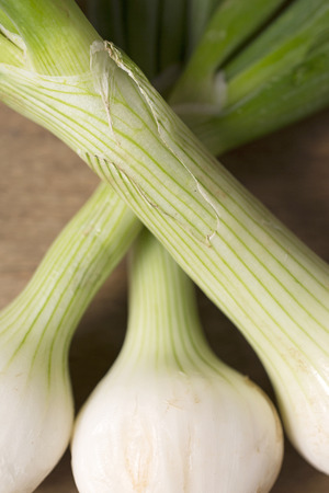 Tasty raw spring onions on a wooden kitchen work topの写真素材