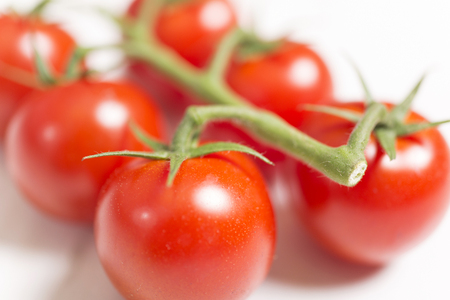 Beautiful fresh tomatoes on a light wooden surfaceの写真素材