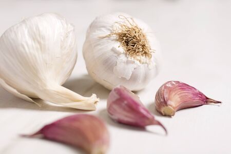 Fresh raw garlic on a light wooden kitchen work surfaceの写真素材