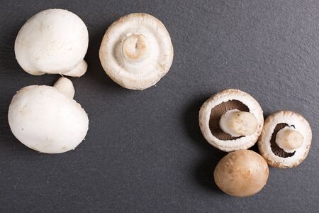 Fresh raw chestnut mushrooms on black slateの写真素材