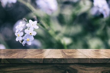 Empty top wooden table and floral blurred backgroundの写真素材