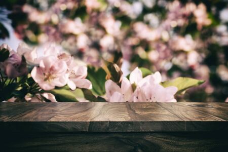 Empty top wooden table and floral blurred backgroundの写真素材